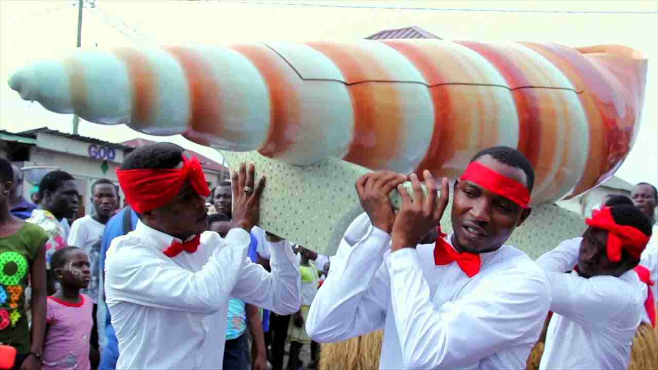 Guys in white and red carrying a designed shell