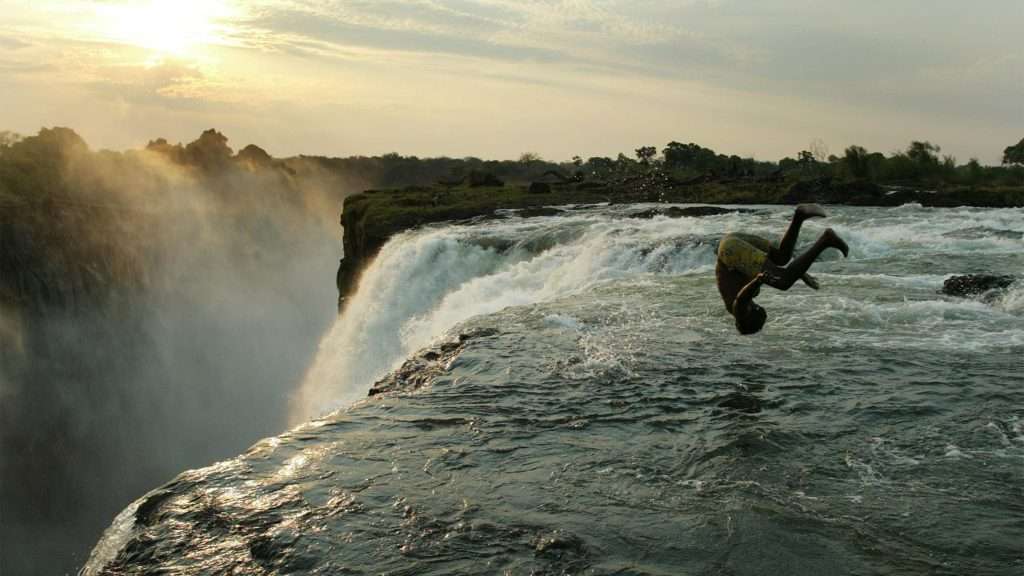 A boy diving into the Victoria Falls
