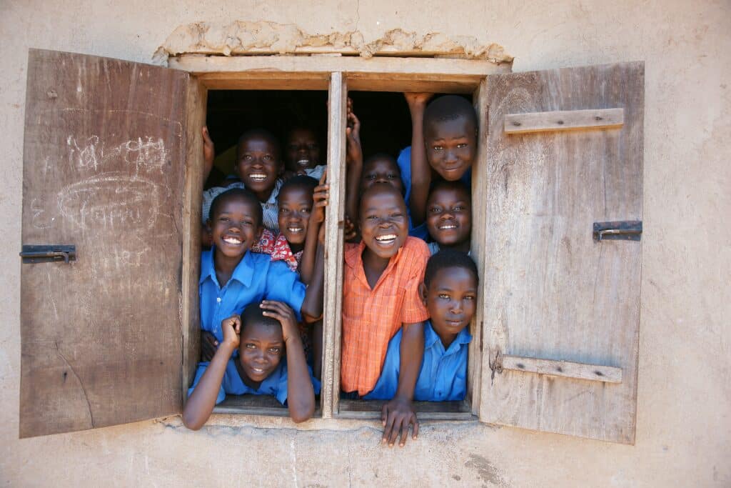 Children smiling from an opened window