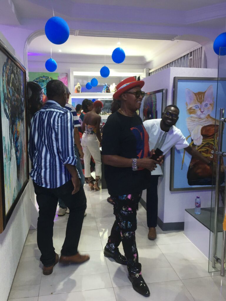 Mr. Ohene Kwaku Genfi spruce in a black t-shirt with red and blue stripes design, a red hat, and a pair of black spectacles
