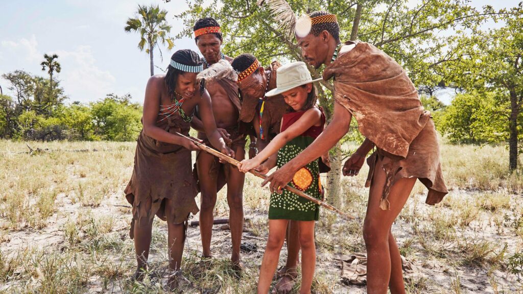 Bushmen with a young tourist girl